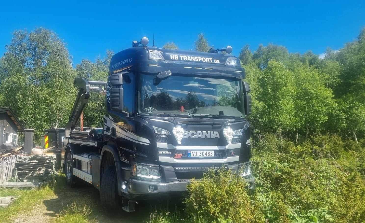 Lastebil med blå container på lasteplan